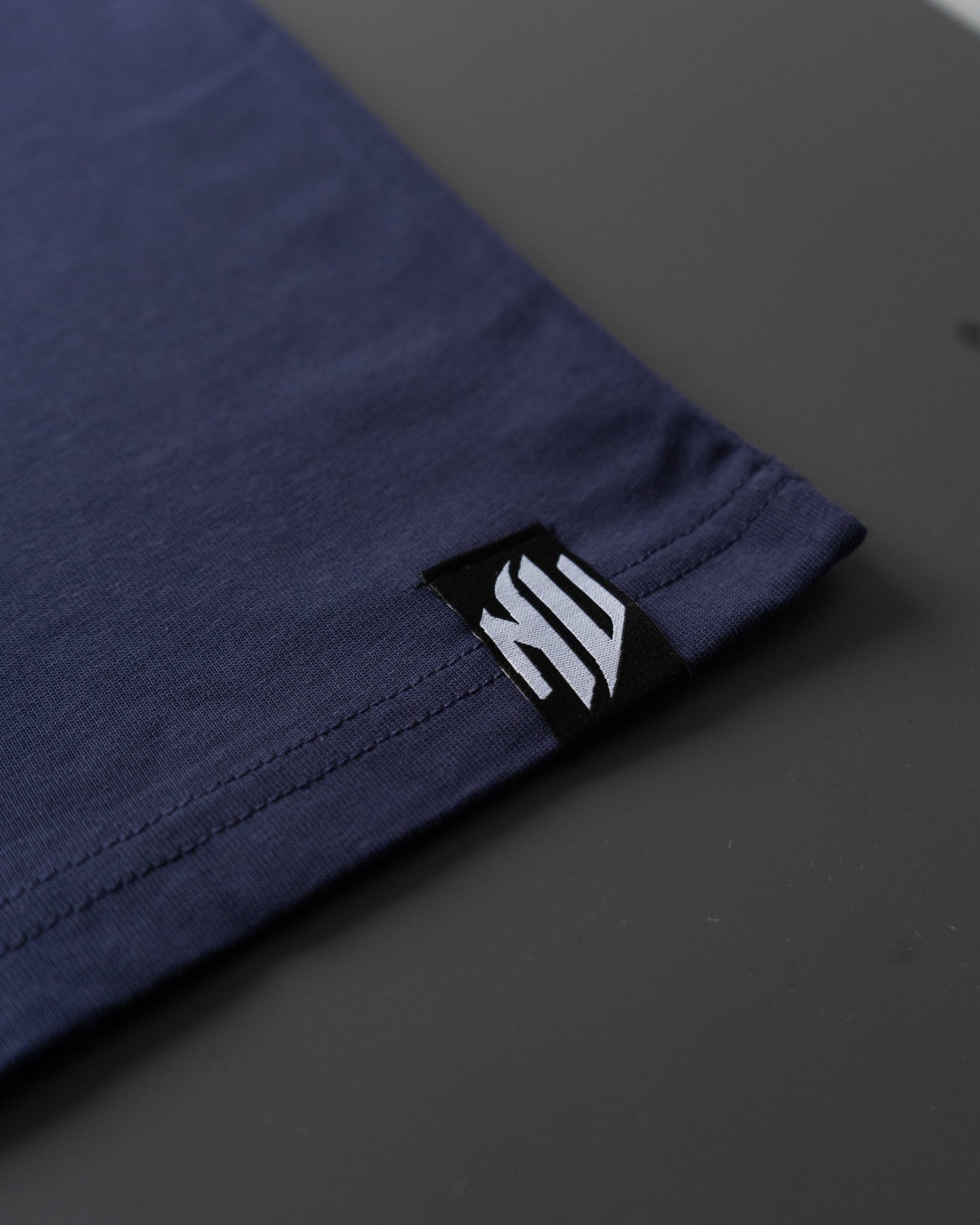 Etiqueta inferior de la camiseta azul de NonVerba.