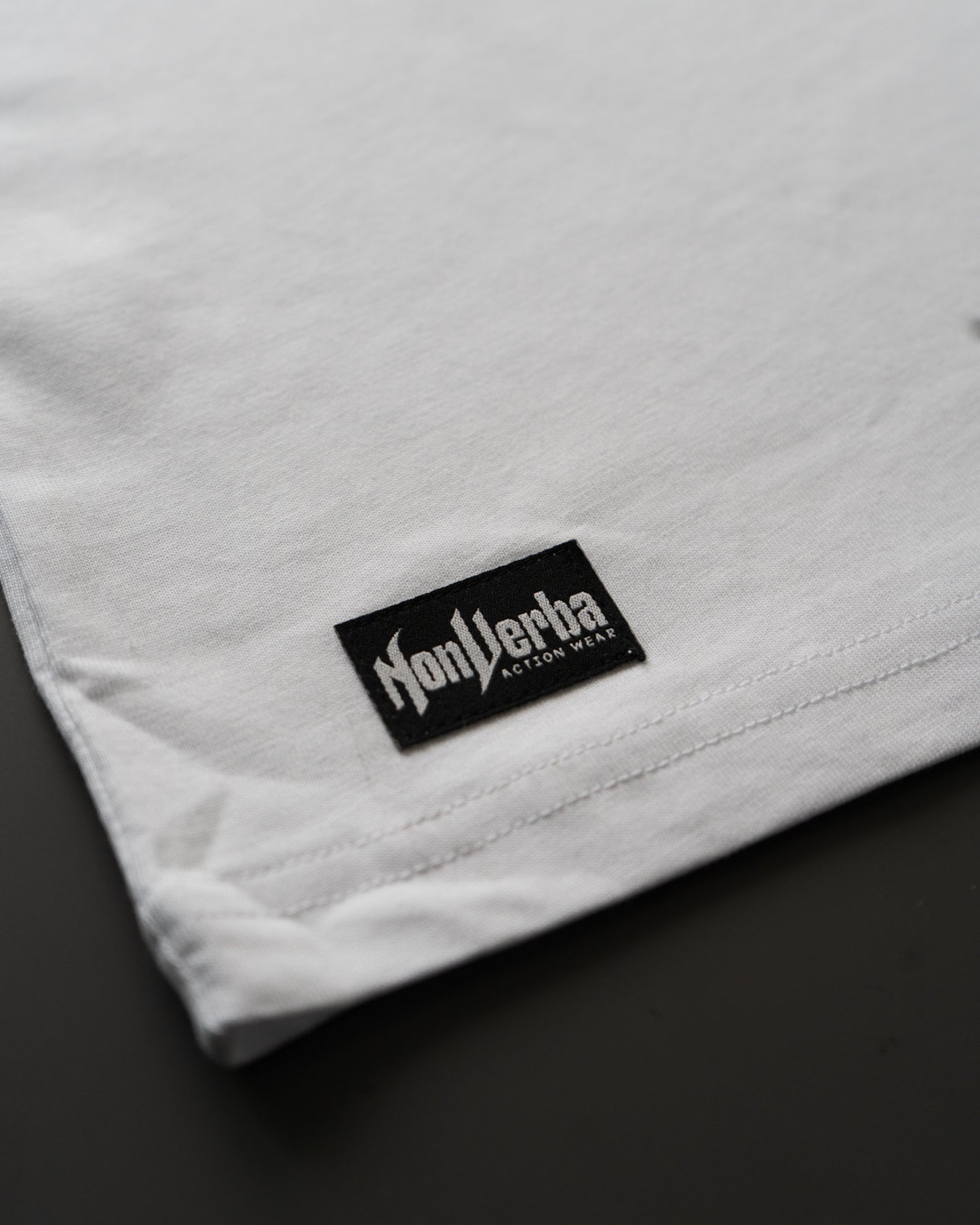 Etiqueta inferior de la camiseta NonVerba blanca.