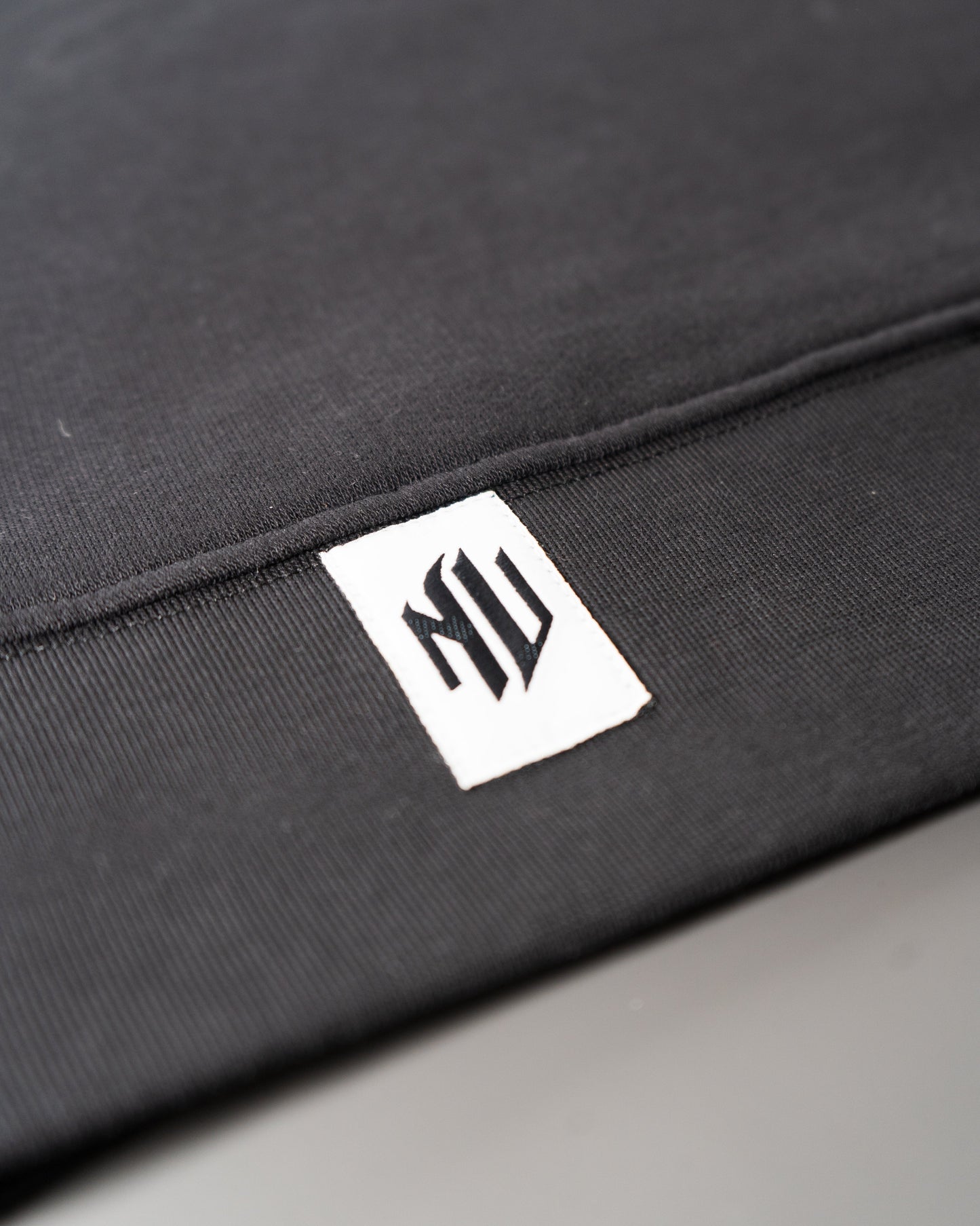 Etiqueta inferior blanca con el logotipo de NonVerba de la hoodie NonVerba.