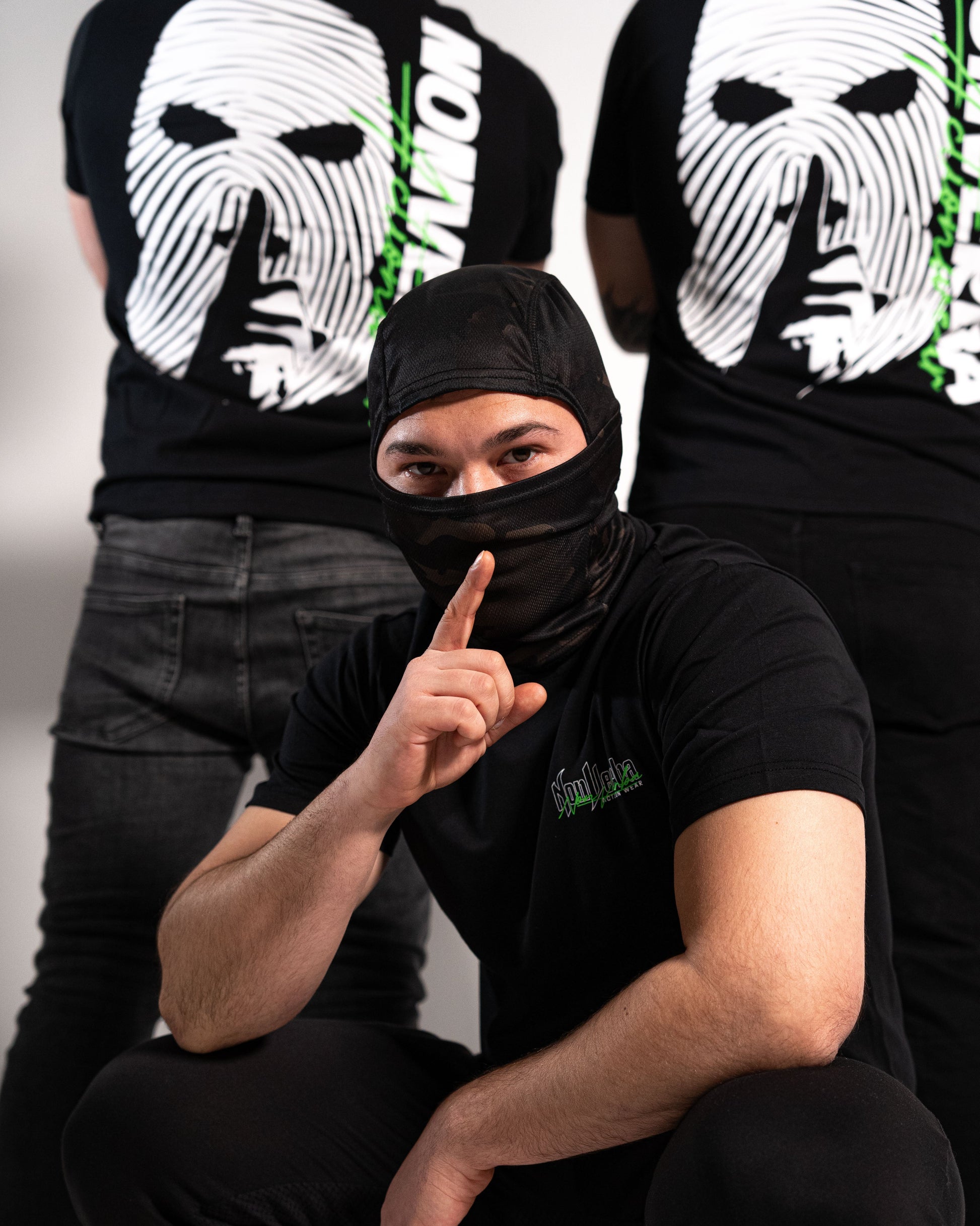 Modelo agachado con la camiseta de manga corta negra de NonVerba