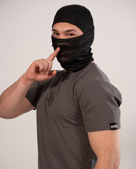Modelo con la camiseta gris de NonVerba, con un dedo sobre la boca mostrando un gesto de silencio.