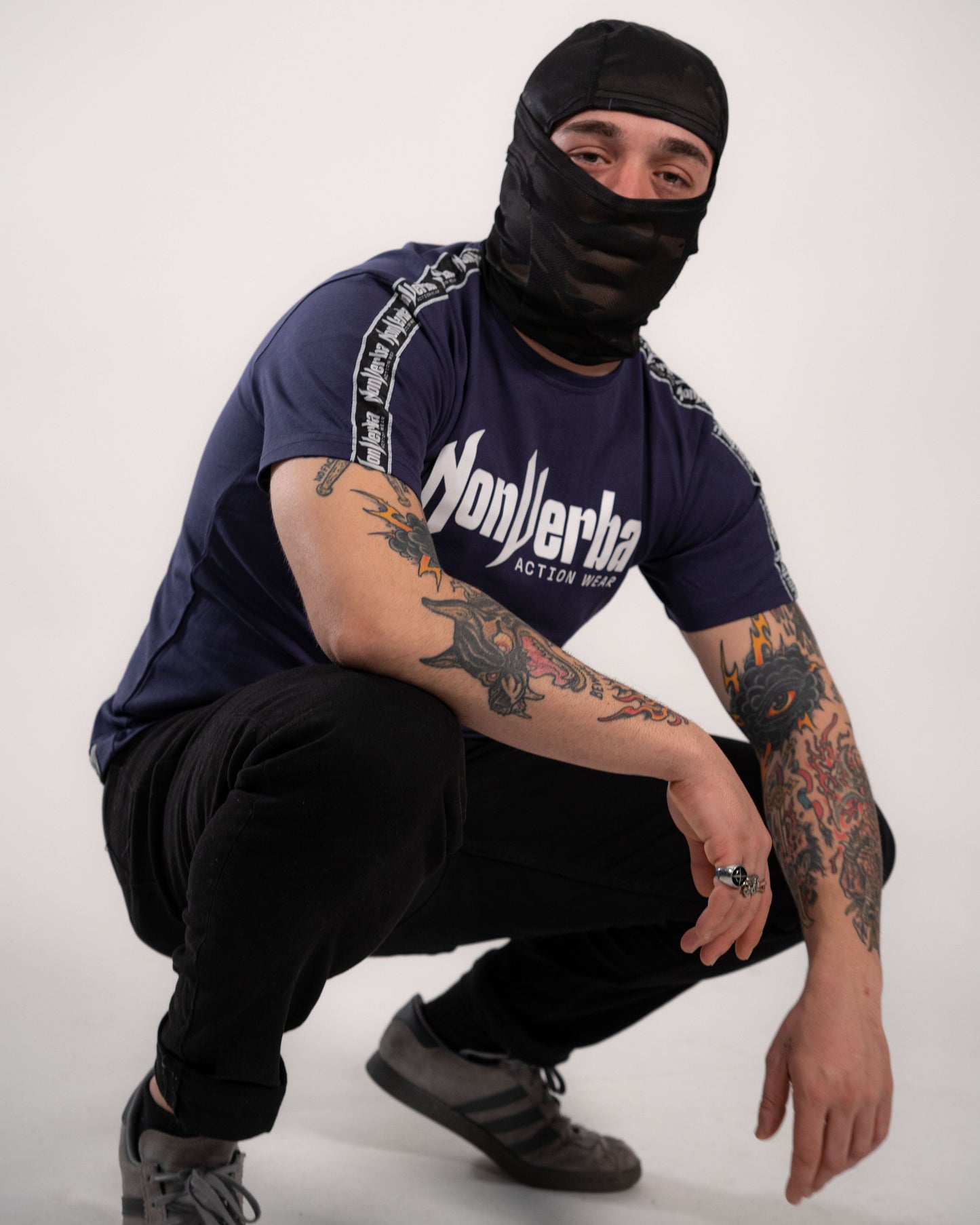 Modelo con la camiseta de NonVerba de color azul y manga corta agacahado.