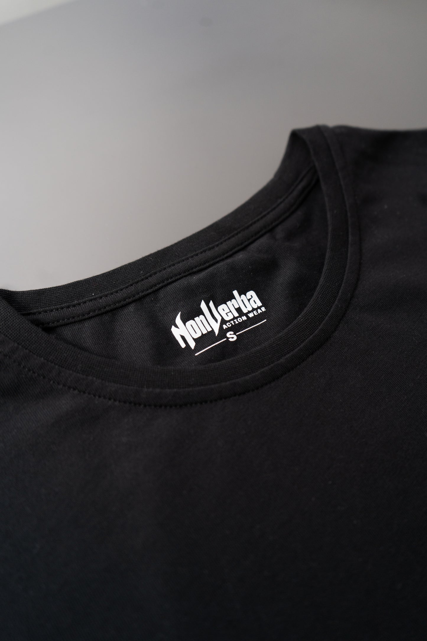 Imagen de la parte trasera del cuello de la camiseta negra de NonVerba.